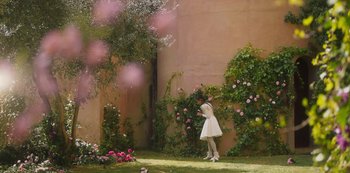 Movie still from “Paradise Hills” (2019), directed by Alice Waddington – A woman in a white dress standing next to a wall; Extreme Wide shot, High angle