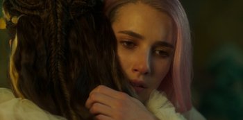 Movie still from “Paradise Hills” (2019), directed by Alice Waddington – A woman with pink hair is holding her head; Close Up shot, Over the shoulder angle