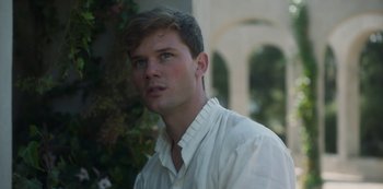 Movie still from “Paradise Hills” (2019), directed by Alice Waddington – A man in a white shirt looking to his left; Close Up shot, Over the shoulder angle