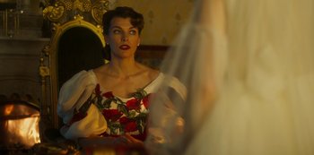 Movie still from “Paradise Hills” (2019), directed by Alice Waddington – A woman in a dress looking in a mirror; Medium shot, Over the shoulder angle