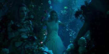 Movie still from “Paradise Hills” (2019), directed by Alice Waddington – A woman in a white dress standing in the middle of a forest; Medium shot, Over the shoulder angle