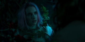 Movie still from “Paradise Hills” (2019), directed by Alice Waddington – A woman with pink hair is standing next to a plant; Close Up shot, Over the shoulder angle