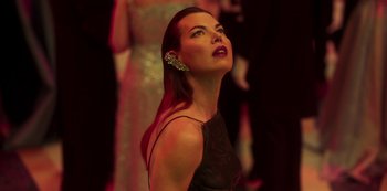 Movie still from “Paradise Hills” (2019), directed by Alice Waddington – A beautiful woman with red hair wearing a black dress; Close Up shot, Low angle