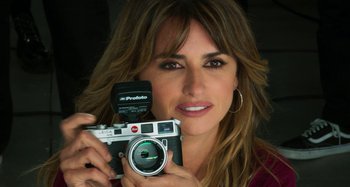 Movie still from “Parallel Mothers” (2021), directed by Pedro Almodóvar – A beautiful woman holding a camera in her hands; Close Up shot, High angle