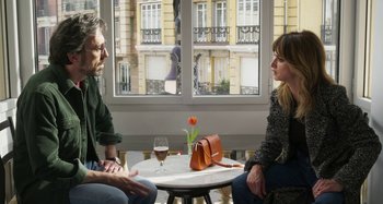 Movie still from “Parallel Mothers” (2021), directed by Pedro Almodóvar – A man and a woman sitting in front of a window; Medium shot, Over the shoulder angle