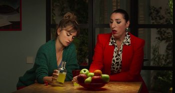 Movie still from “Parallel Mothers” (2021), directed by Pedro Almodóvar – Two women sitting at a table in front of a bowl of fruit; Medium shot, Over the shoulder angle