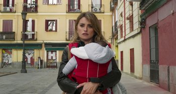 Movie still from “Parallel Mothers” (2021), directed by Pedro Almodóvar – A woman holding a baby in a sling; Close Up shot, Low angle