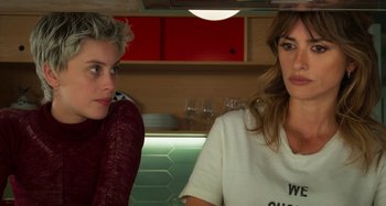Movie still from “Parallel Mothers” (2021), directed by Pedro Almodóvar – Two women sitting in front of each other in front of a counter; Close Up shot, Over the shoulder angle