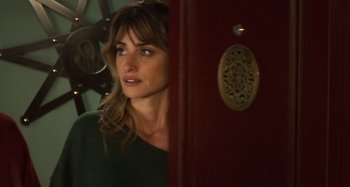 Movie still from “Parallel Mothers” (2021), directed by Pedro Almodóvar – A woman standing in front of a door looking to her left; Close Up shot, Over the shoulder angle