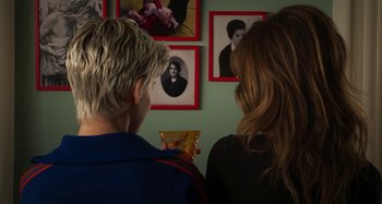 Movie still from “Parallel Mothers” (2021), directed by Pedro Almodóvar – Two people are looking at pictures on the wall; Close Up shot, Over the shoulder angle