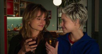 Movie still from “Parallel Mothers” (2021), directed by Pedro Almodóvar – A woman and a boy looking at each other with drinks; Close Up shot, Over the shoulder angle