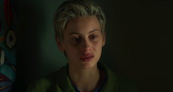 Movie still from “Parallel Mothers” (2021), directed by Pedro Almodóvar – A young man with blonde hair is looking at the camera; Close Up shot, Over the shoulder angle