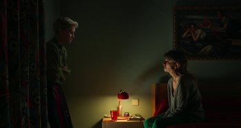 Movie still from “Parallel Mothers” (2021), directed by Pedro Almodóvar – Two women sitting on a bed talking to each other; Medium shot, Over the shoulder angle