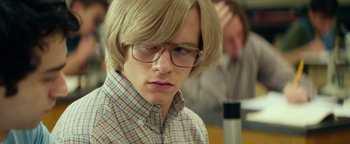Movie still from “My Friend Dahmer” (2017), directed by Marc Meyers – A man with blonde hair wearing glasses and a plaid shirt; Close Up shot, Low angle