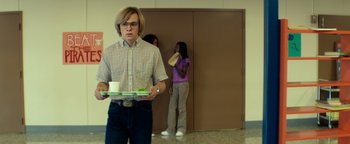 Movie still from “My Friend Dahmer” (2017), directed by Marc Meyers – A man holding a tray in front of two women; Medium shot, Low angle