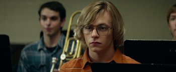 Movie still from “My Friend Dahmer” (2017), directed by Marc Meyers – A young man with glasses is sitting in front of a trombone; Close Up shot, Low angle