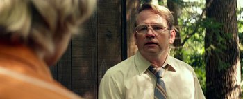 Movie still from “My Friend Dahmer” (2017), directed by Marc Meyers – A man wearing a tie and glasses looking at the camera; Close Up shot, Over the shoulder angle
