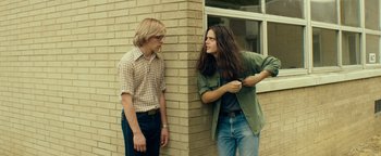 Movie still from “My Friend Dahmer” (2017), directed by Marc Meyers – Two young men standing next to a brick wall; Medium shot, Low angle