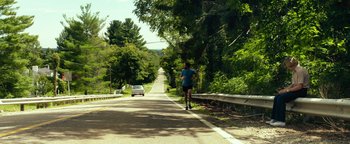 Movie still from “My Friend Dahmer” (2017), directed by Marc Meyers – A man running down the side of a road; Extreme Wide shot, High angle