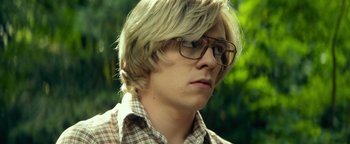 Movie still from “My Friend Dahmer” (2017), directed by Marc Meyers – A man with blonde hair wearing glasses and a plaid shirt; Close Up shot, Low angle