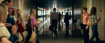 Movie still from “My Friend Dahmer” (2017), directed by Marc Meyers – A group of people walking down a hall way; Wide shot, Over the shoulder angle