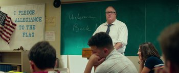 Movie still from “My Friend Dahmer” (2017), directed by Marc Meyers – A man standing in front of a chalkboard; Medium shot, Over the shoulder angle