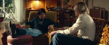 Movie still from “My Friend Dahmer” (2017), directed by Marc Meyers – Two people sitting on a couch in a living room; Medium shot, Over the shoulder angle