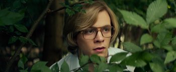 Movie still from “My Friend Dahmer” (2017), directed by Marc Meyers – A man with glasses is standing next to a tree; Close Up shot, Over the shoulder angle
