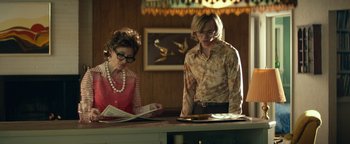 Movie still from “My Friend Dahmer” (2017), directed by Marc Meyers – Two women sitting at a counter looking at papers; Medium shot, Low angle
