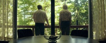 Movie still from “My Friend Dahmer” (2017), directed by Marc Meyers – A man and a woman looking out a window; Medium shot, Low angle
