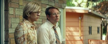 Movie still from “My Friend Dahmer” (2017), directed by Marc Meyers – A man and a woman standing next to each other; Medium shot, Low angle