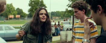 Movie still from “My Friend Dahmer” (2017), directed by Marc Meyers – A man with long hair standing next to a woman; Medium shot, Over the shoulder angle