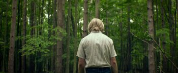 Movie still from “My Friend Dahmer” (2017), directed by Marc Meyers – A man standing in the middle of a forest; Medium shot, Low angle