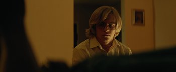 Movie still from “My Friend Dahmer” (2017), directed by Marc Meyers – A man with blonde hair wearing glasses looking at a mirror; Close Up shot, Over the shoulder angle