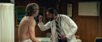 Movie still from “My Friend Dahmer” (2017), directed by Marc Meyers – A man in a white lab coat is brushing his teeth; Medium shot, Over the shoulder angle