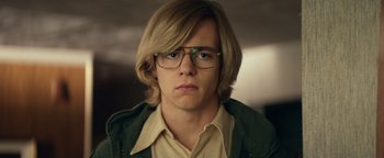 Movie still from “My Friend Dahmer” (2017), directed by Marc Meyers – A man with blonde hair wearing glasses and a green jacket; Close Up shot, Low angle