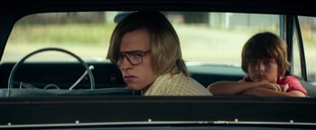 Movie still from “My Friend Dahmer” (2017), directed by Marc Meyers – A man with glasses sitting in the back seat of a car; Close Up shot, Over the shoulder angle