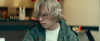 Movie still from “My Friend Dahmer” (2017), directed by Marc Meyers – A young man with blonde hair wearing glasses and a green jacket; Close Up shot, Low angle