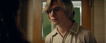 Movie still from “My Friend Dahmer” (2017), directed by Marc Meyers – A young man with blonde hair wearing glasses and a tan shirt; Close Up shot, Over the shoulder angle