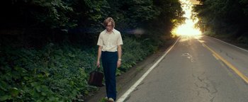 Movie still from “My Friend Dahmer” (2017), directed by Marc Meyers – A man walking down the side of a road holding a briefcase; Wide shot, Low angle