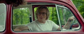 Movie still from “My Friend Dahmer” (2017), directed by Marc Meyers – A young man sitting in the driver's seat of a red car; Medium shot, Over the shoulder angle