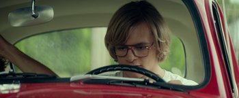 Movie still from “My Friend Dahmer” (2017), directed by Marc Meyers – A young man driving a red car in the road; Close Up shot, Over the shoulder angle