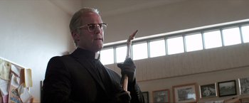Movie still from “Parker” (2013), directed by Taylor Hackford – A man in a priest's outfit holding a copper pipe; Close Up shot, Low angle