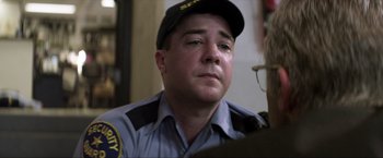 Movie still from “Parker” (2013), directed by Taylor Hackford – A man in a police officer's uniform looking down; Close Up shot, Over the shoulder angle