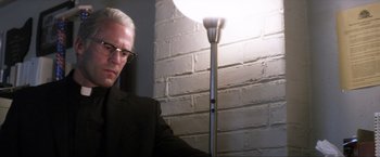 Movie still from “Parker” (2013), directed by Taylor Hackford – A man standing next to a lamp in front of a brick wall; Close Up shot, Low angle