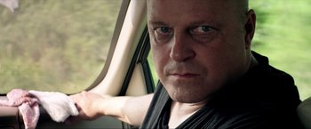 Movie still from “Parker” (2013), directed by Taylor Hackford – A person sitting in a car looking at the camera; Close Up shot, Over the shoulder angle
