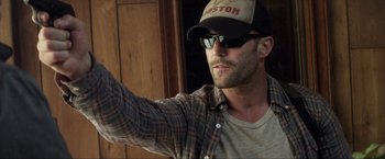 Movie still from “Parker” (2013), directed by Taylor Hackford – A person wearing a hat and sunglasses; Close Up shot, Over the shoulder angle