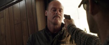 Movie still from “Parker” (2013), directed by Taylor Hackford – A man holding a cell phone up to his ear; Close Up shot, Over the shoulder angle
