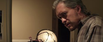Movie still from “Parker” (2013), directed by Taylor Hackford – A person looking at a lamp; Close Up shot, Low angle