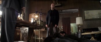 Movie still from “Parker” (2013), directed by Taylor Hackford – A man standing next to a man laying on the ground; Wide shot, Low angle